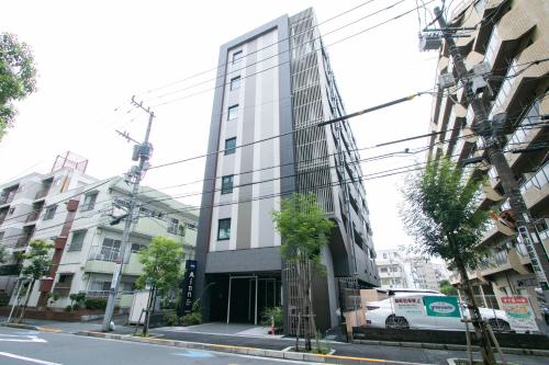 a tall glass building on a city street at Minn Nishi Kasai in Tokyo