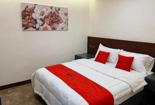 1 dormitorio con 1 cama grande con almohadas rojas en RedDoorz Plus @ Toshiko Boutique Hotel Koronadal City, en Koronadal