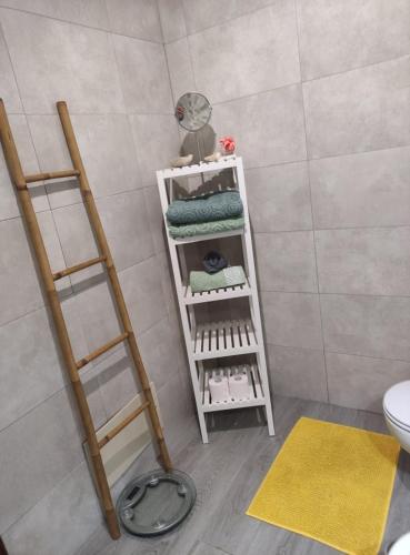 a bathroom with a white shelf with towels and a fan at A Casa da Nocas in Setúbal