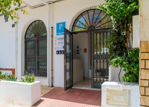 an entrance to a building with a gate and a parking meter at La Moraga de Poniente Malaga Hostel in Málaga