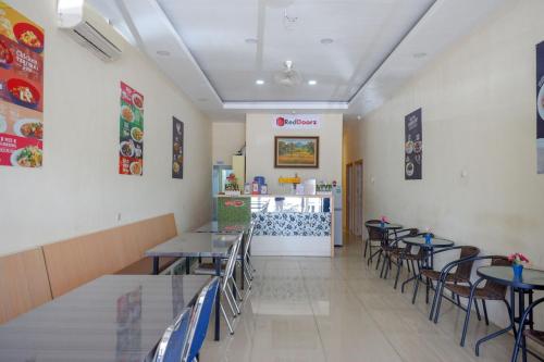 ein Esszimmer mit Tischen, Stühlen und einer Theke in der Unterkunft RedDoorz Plus @ Losari Makassar in Makassar