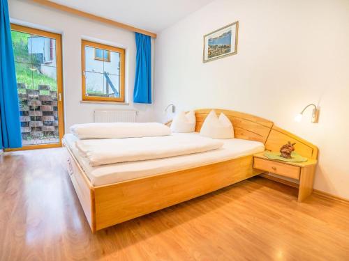 a bedroom with a wooden bed in a room at Beautiful Apartment in Stubaital in a quiet location in Neustift im Stubaital