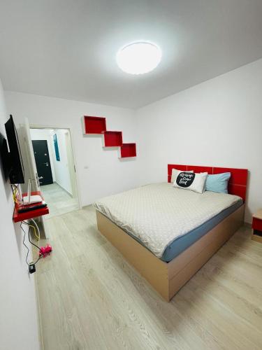 ein Schlafzimmer mit einem Bett und einem Flachbildfernseher in der Unterkunft Grandis Residence in Braşov