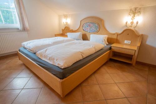 a bedroom with a large bed with a wooden headboard at Appartement Egghof in Berwang