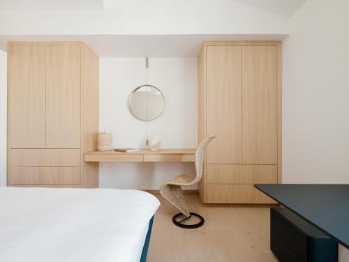 1 dormitorio con cama y escritorio con espejo en Fully serviced apartment with spectacular views towards the Munch Museum, en Oslo