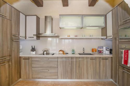 a kitchen with wooden cabinets and a sink at Tfiefa Holiday Home in Xagħra