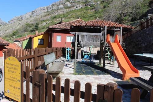 a playground with an orange slide at La Congosta, mágica aldea rodeada de montañas in La Plaza