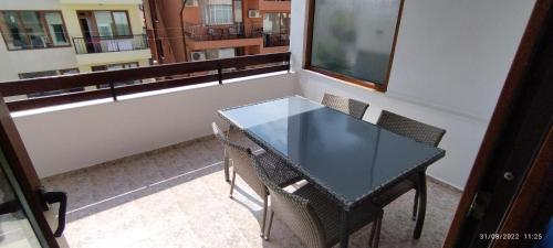 Apartment Milanovi في سوزوبول: طاولة زجاجية وكراسي في الغرفة