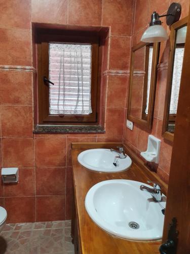 a bathroom with two sinks and a window at Casa Celedonio in Cerredo