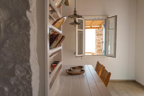 a dining room with a table and a window at Blue Calm Luxury Villa in Sifnos in Artemonas