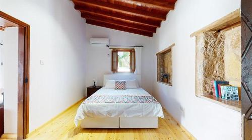 a bedroom with a bed in a white room at Templos Homes in Kérynia