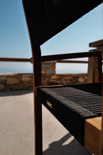 a close up of a wooden bench with the ocean in the background at Blue Calm Luxury Villa in Sifnos in Artemonas