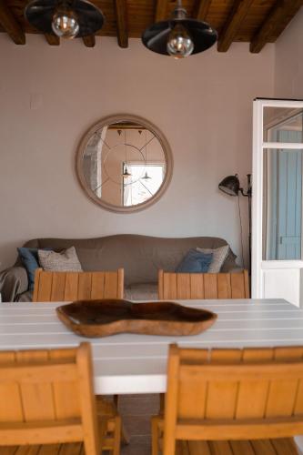 a dining room table with a couch and a mirror at Blue Calm Luxury Villa in Sifnos in Artemonas