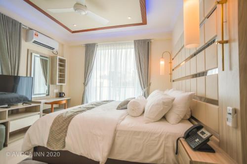 a hotel room with a bed and a television at Avoca Inn in Hulhumale