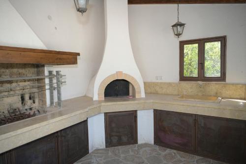 a kitchen with a counter top and a fireplace at AnaMar Eternity House in Asprókambos