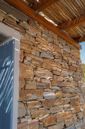 a stone wall with a wooden roof at Blue Calm Luxury Villa in Sifnos in Artemonas