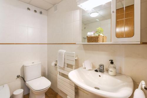 a white bathroom with a toilet and a sink at Blue Marlin in Balcon del Mar
