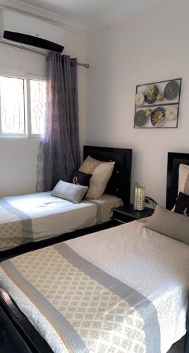 a bedroom with two beds and a window at Riad Lyna in Marrakech