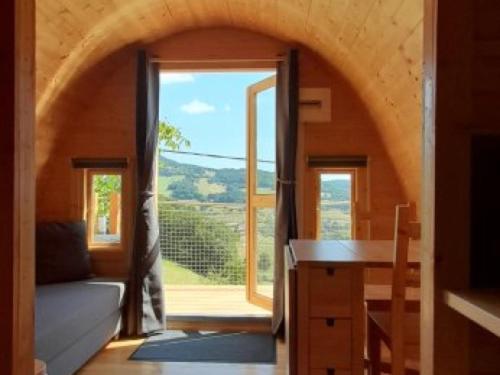 un salon avec une grande fenêtre et un canapé dans l'établissement Logement insolite Pod Lo Tchan, à Fréland