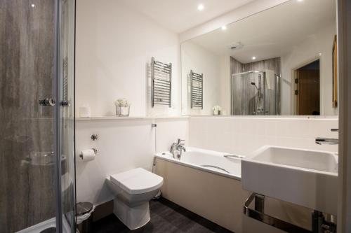 a bathroom with a sink and a toilet and a tub at Urban Living's - The Wren Beautiful City Centre Apartment with Parking in Oxford