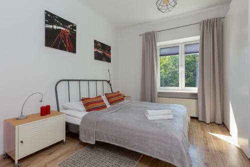 Apartment Bialobrzeska Warsaw by Renters في وارسو: غرفة نوم بيضاء بها سرير ونافذة