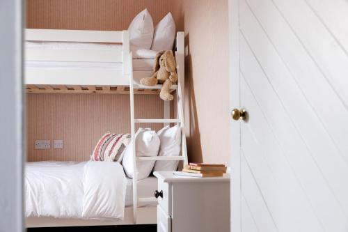 1 dormitorio con literas y un osito de peluche en un estante en Suir Valley Cottage. 