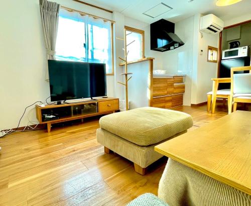 a living room with a large flat screen tv at 上落合ハウス KAMIOCHIAI HOUSE in Tokyo