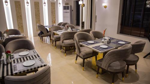 Hotel Royal 9 في ميروت: مطعم فيه طاولات وكراسي في الغرفة