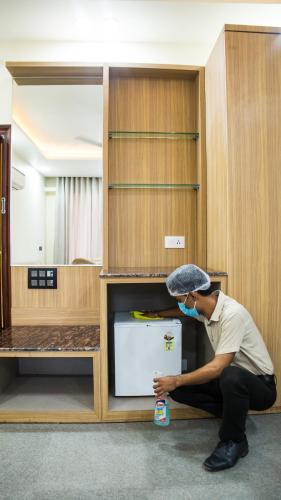 a man is sitting on the floor in a cabinet at Royal 9 hotel & Banquet in Meerut
