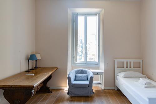een slaapkamer met een bed, een bureau en een stoel bij Comfy Apartment Near Fortezza Da Basso in Florence