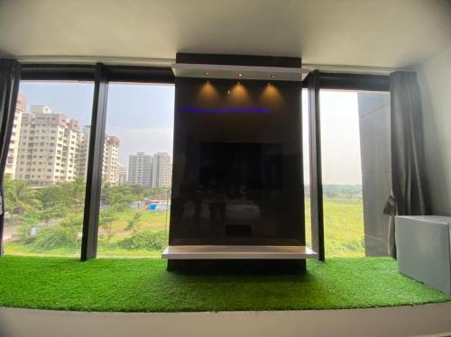 a living room with a fireplace and green grass at HOTEL CROWN PALACE in Surat