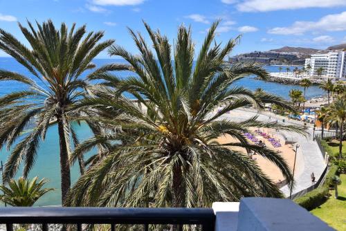 vistas a una playa con palmeras y al océano en Balcon del Mar MG by VillaGranCanaria, en Arguineguín
