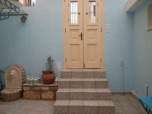 a door in a room with stairs and a plant at studio ANAIS in Galaxidhion