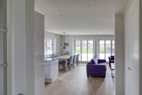 a kitchen and living room with a table and chairs at Rantum Dorf - Ferienappartments im Reetdachhaus 3 & 4 in Rantum