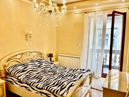 1 cama con estampado de cebra en un dormitorio con lámpara de araña en Belgrade heart of a historical center, en Belgrado