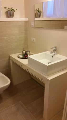 a bathroom with a white sink and a toilet at B&B Aria d'Argento & Relax Home in Trento