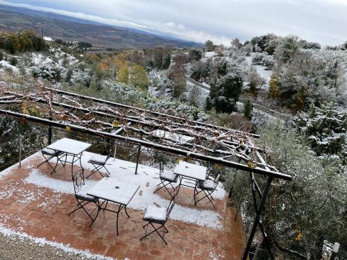 a group of tables and chairs in the snow at Podere Belsogno-Camera rosmarino in Montalcino