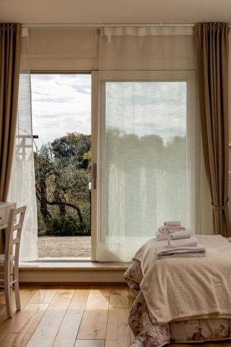 a bedroom with a bed and a large window at Podere Belsogno-Camera rosmarino in Montalcino
