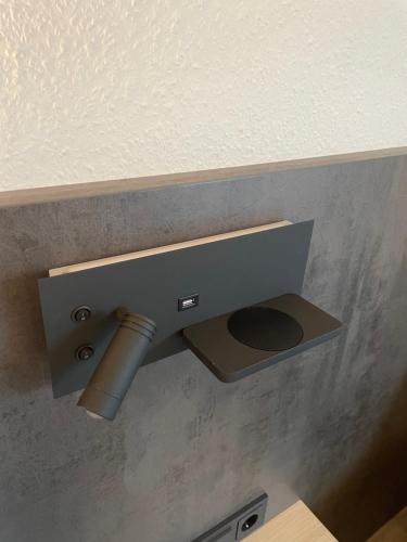 a metal toilet paper dispenser on a wall at Hotel Corsten in Heinsberg