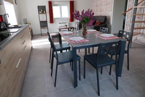 a kitchen and dining room with a table and chairs at Le Sophora in Chéu