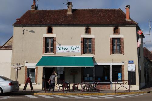 a person walking in front of a building with a green awning at Le Sophora in Chéu