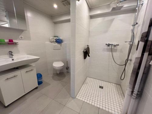 a white bathroom with a shower and a sink at FeWo-Erika in Archsum