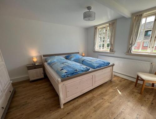 una camera da letto con un letto con lenzuola blu sopra di FeWo-Erika ad Archsum