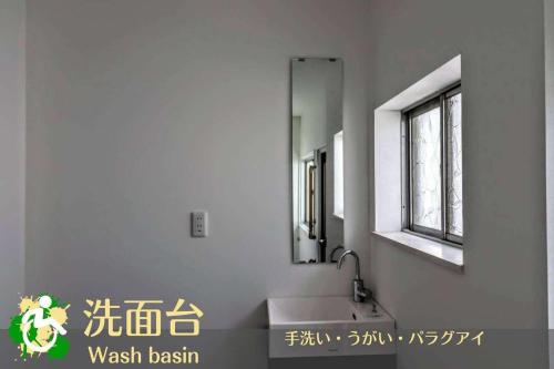 a bathroom with a sink and a mirror at WADACHI in Osaka