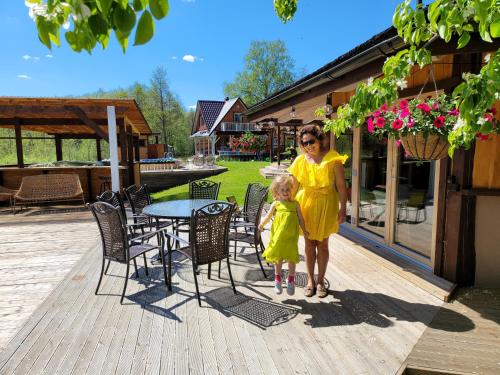 a woman and a little girl standing on a deck at Neitsijärve majutus in Otepää