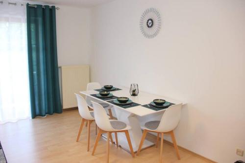 a white dining room with a white table and chairs at Ferienwohnung mit Balkon in Schwandorf in Bayern