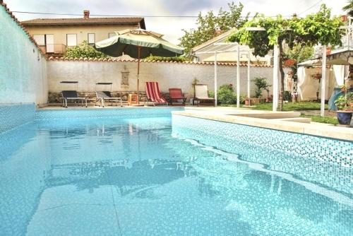 een zwembad met blauw water voor een huis bij Apartments with swimming pool Valbandon, Fazana - 7257 in Marana