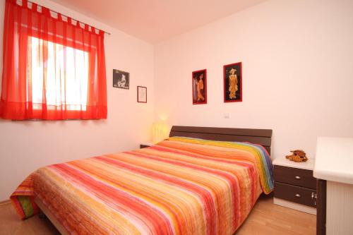 een slaapkamer met een bed en een raam met rode gordijnen bij Apartments with a parking space Valbandon, Fazana - 7258 in Fondole