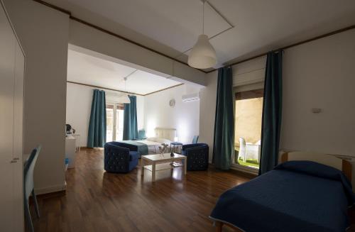 a bedroom with two beds and a table in a room at Doctor House standard, suites & luxury rooms in Enna