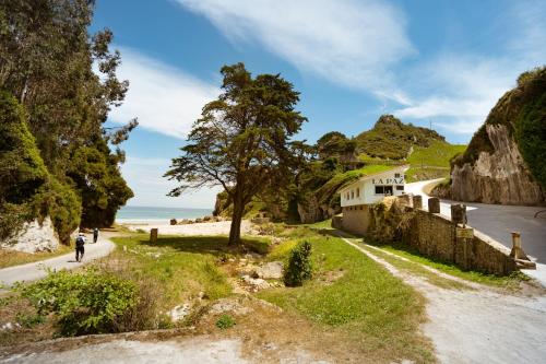 Vidiago的住宿－Kampaoh Llanes，沿着海滩旁的道路骑着自行车的人